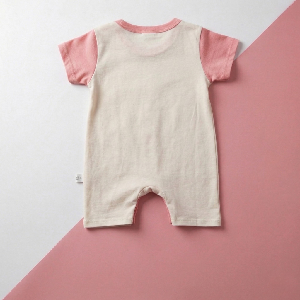 Baby romper with pink sleeves on a white and pink background