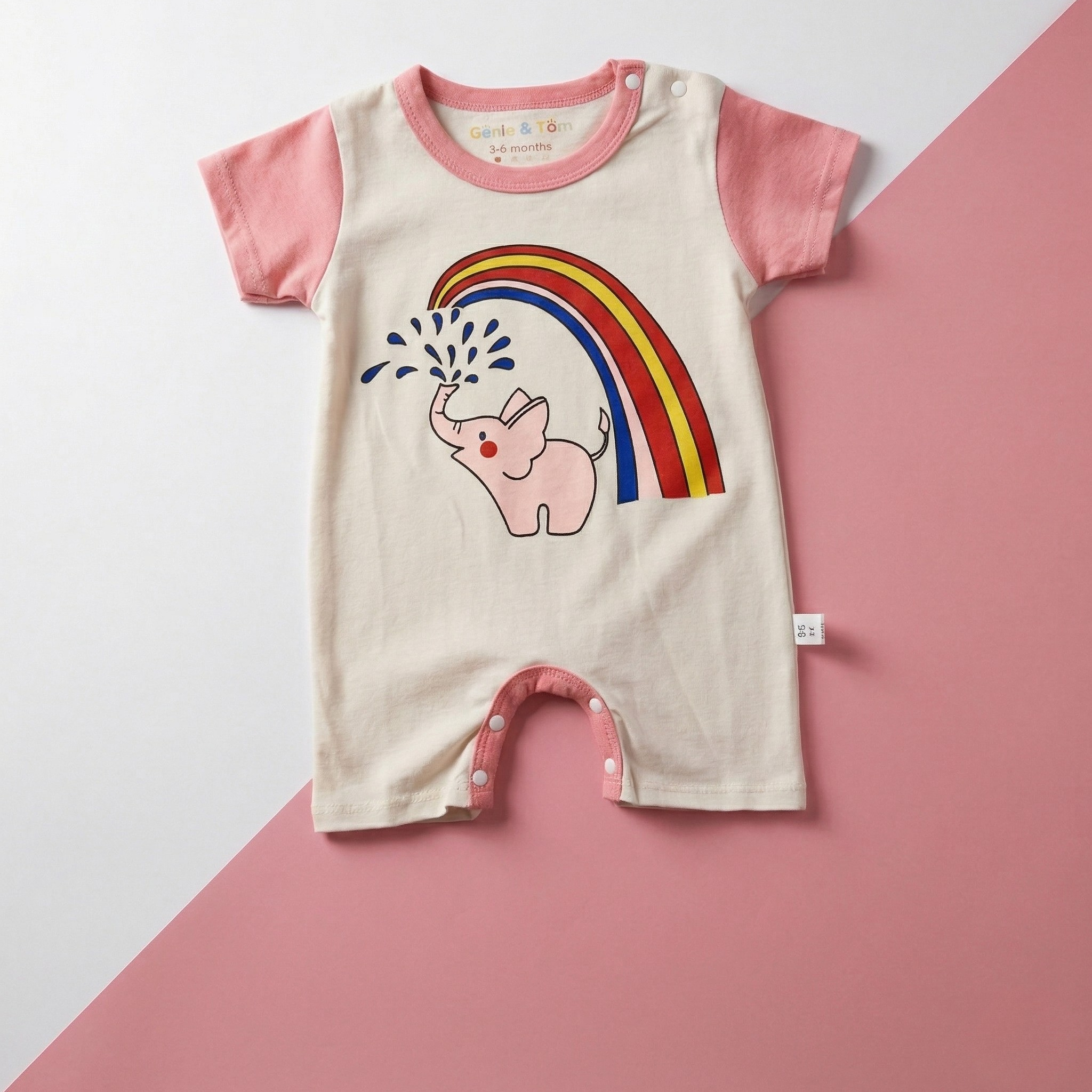 Baby romper with pink elephant and rainbow design on a pink and white background